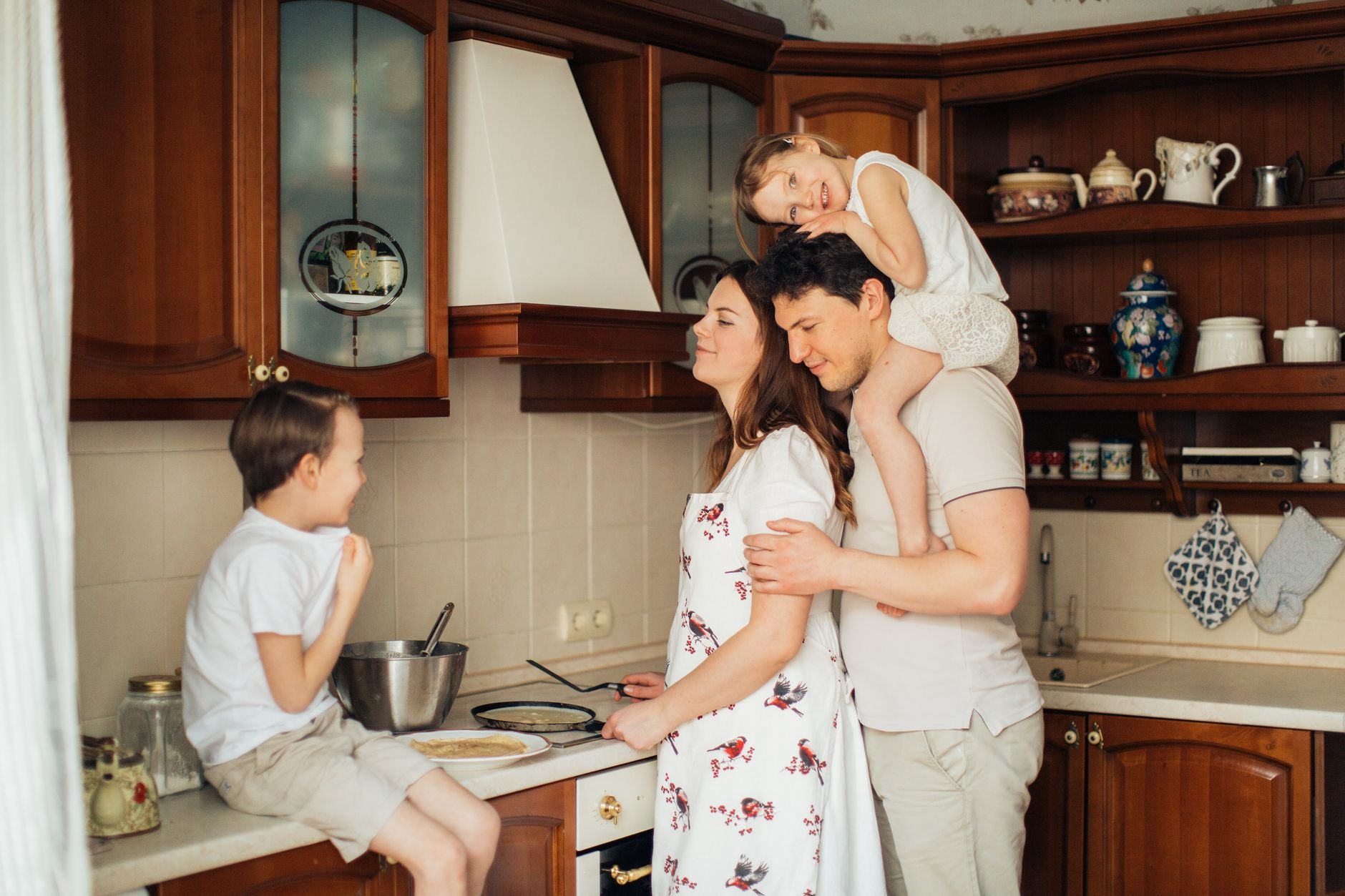 A joyful family moment as parents and children cook together in a cozy kitchen setting.